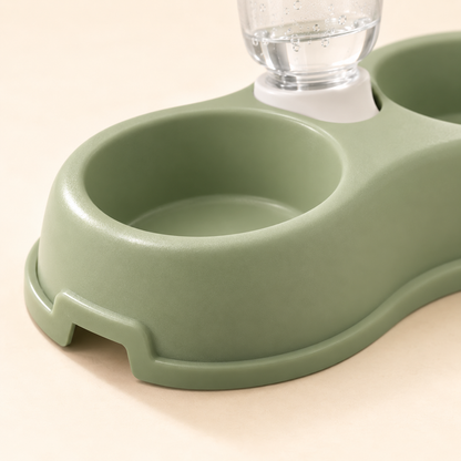 Close-up of the sage green double bowl feeding station and the white collar of the gravity water bottle