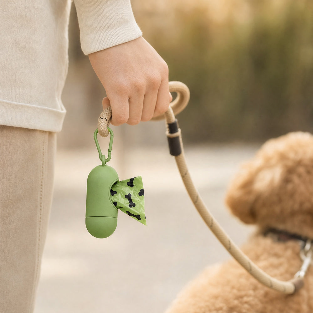 Poop bag dispenser clipped to a leash during a dog walk